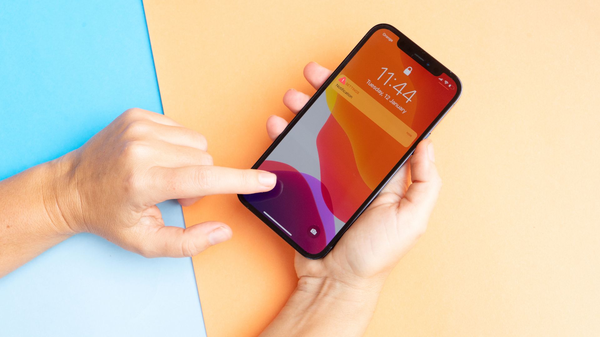 Hands holding smartphone with notification on colorful background